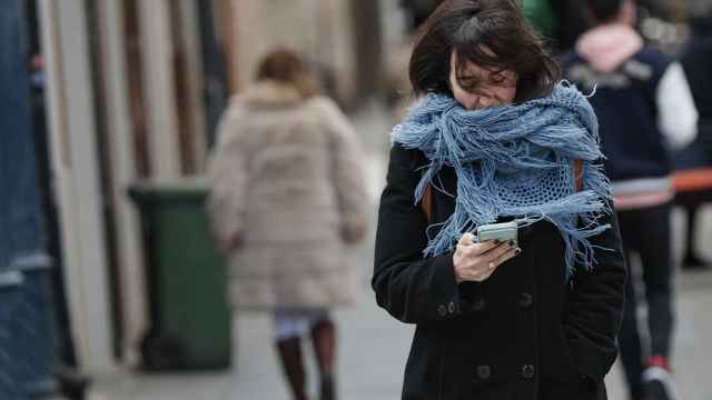 Una persona se resguarda del frío en una foto de archivo