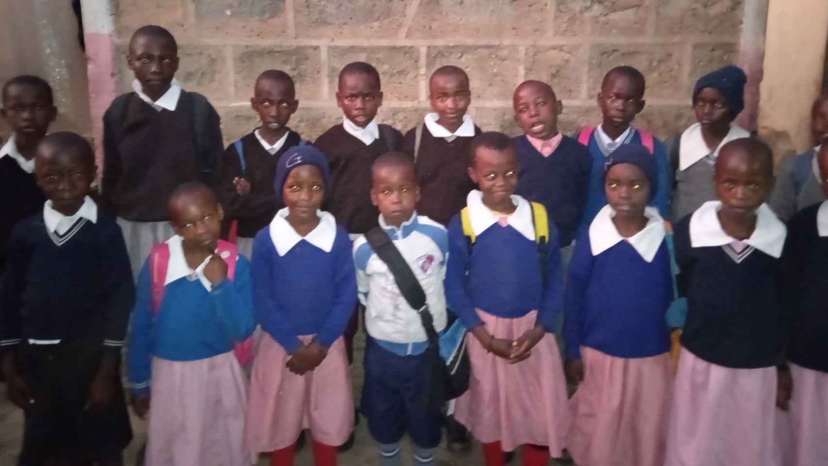 Niños con uniforme, dispuestos a ir a la escuela.