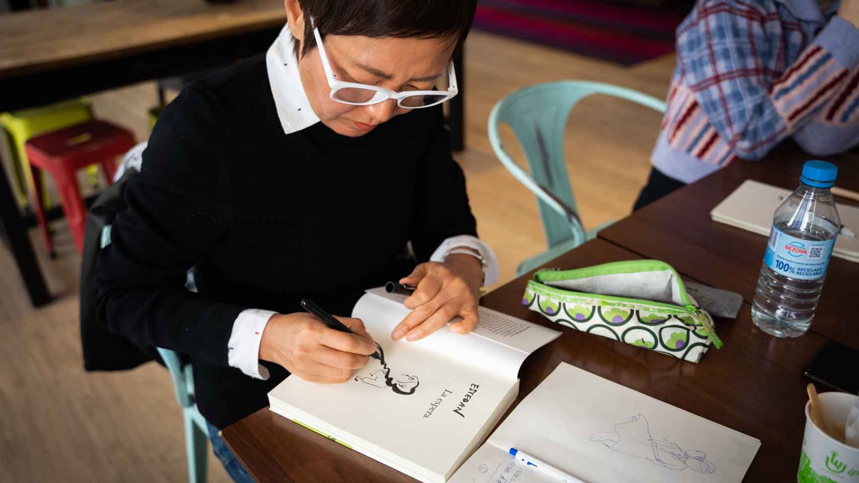 La ilustradora surcoreana Keum Suk Gendry-Kim firmando un ejemplar de su libro 'La Espera'.