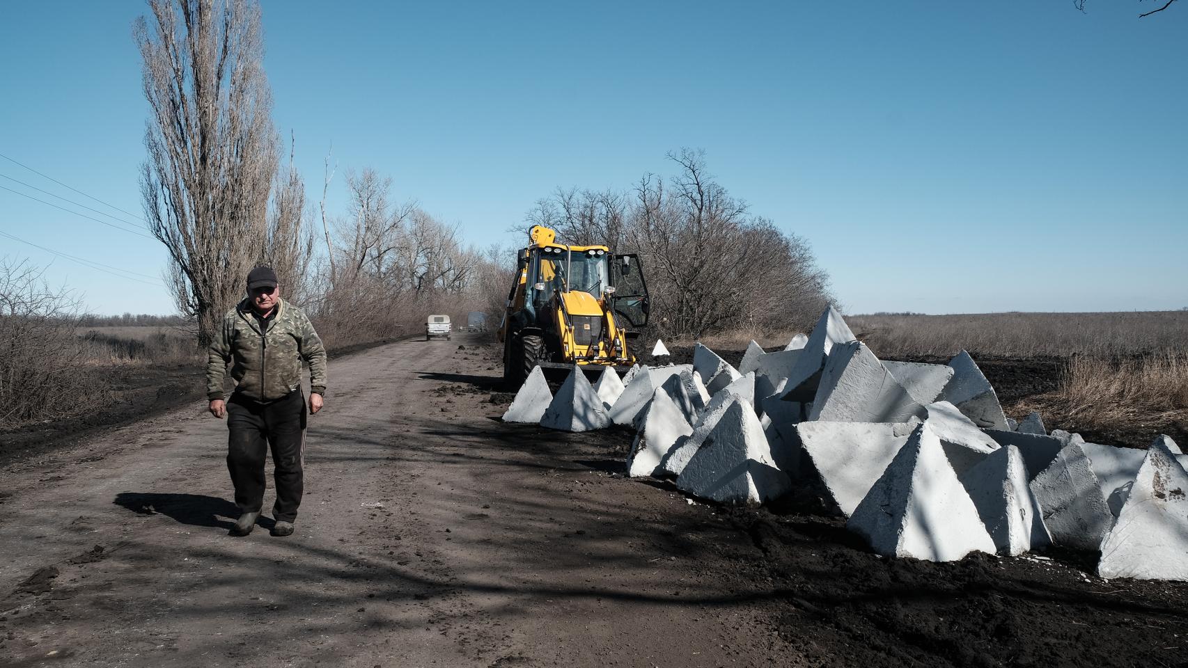 A worker places concrete blocks on the roads around Bakhmut.