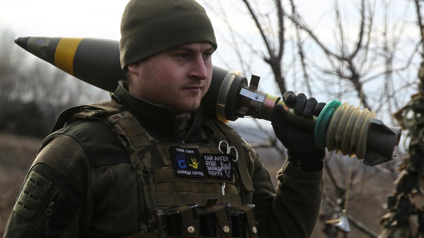 A Ukrainian service member carries a mortar shell before firing on Russian troops outside the town of Bakhmut.