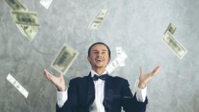 Imagen de archivo de una persona feliz con dinero.