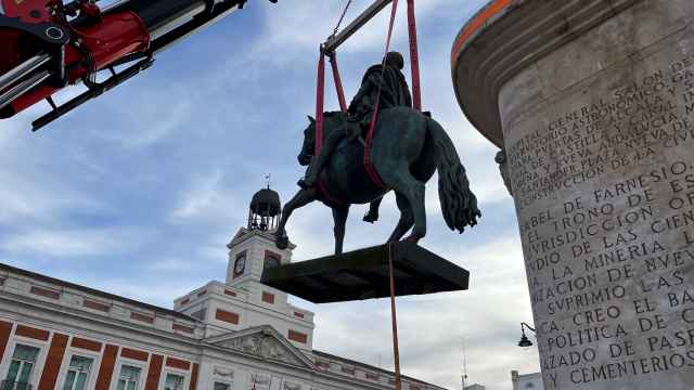 Imagen de la bajada de la estatua de Carlos III con la ayuda de una grúa.