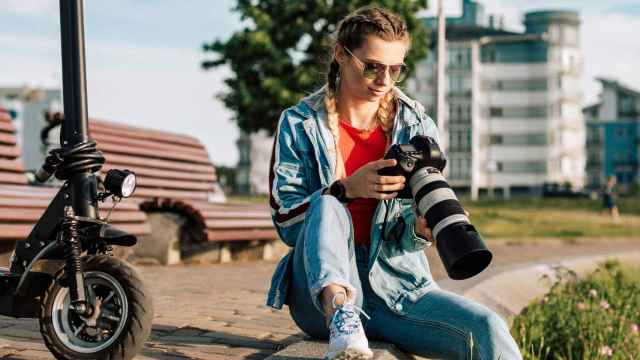 Una mujer fotógrafa revisando algunas imágenes en su cámara.