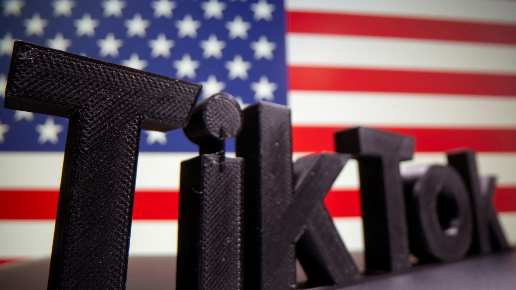 Logo de TikTok impreso en 3D delante de la bandera de Estados Unidos.