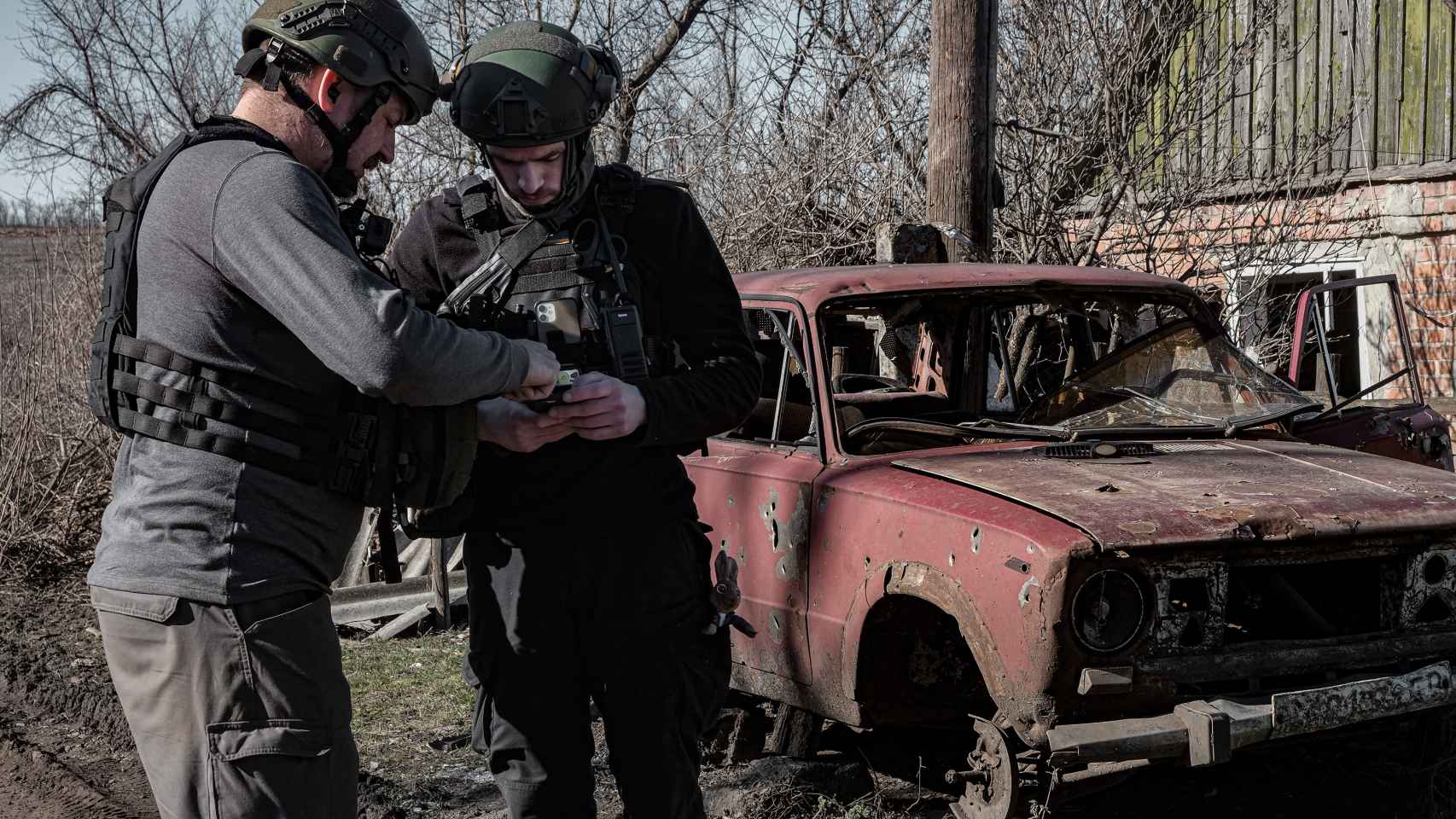 Los rescatistas, Michael (izquierda) y Artem (derencha) consultan una dirección en sus teléfonos durante una de las evacuaciones que realizan en los alrededores de Bakhmut.