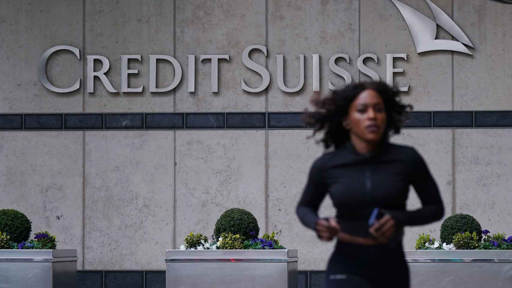 Una mujer pasa corriendo delante de las oficinas de Credit Suisse en Londres.