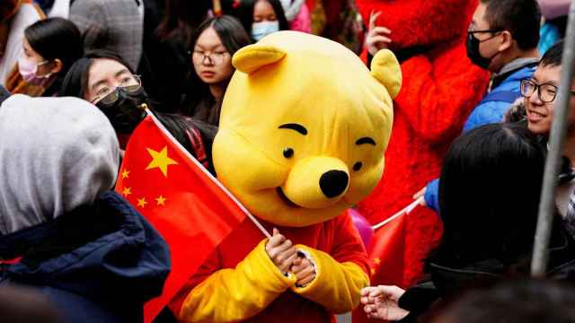 Una persona disfrazada de Winnie the Pooh ondea una bandera china en Nueva York.