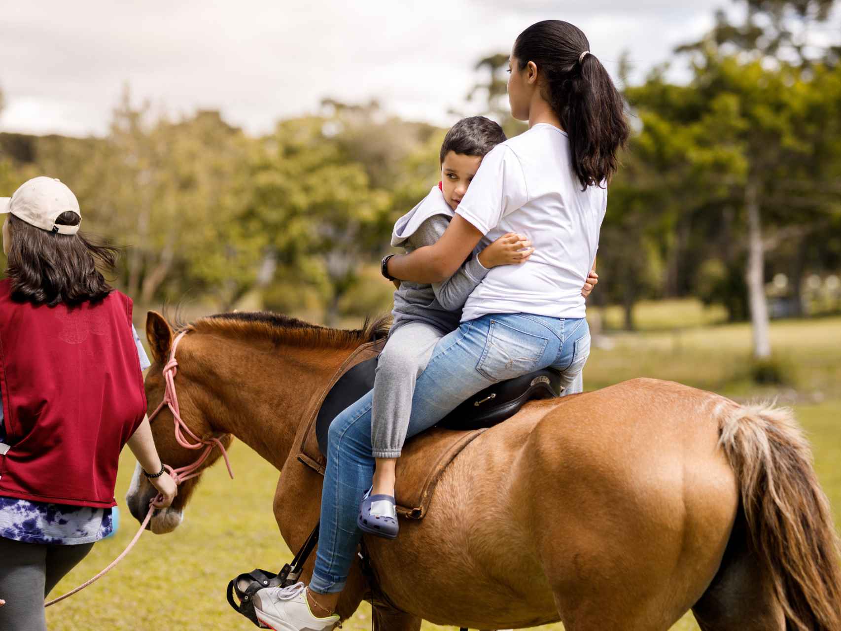 Un niño con síndrome de Down monta y abraza un caballo.