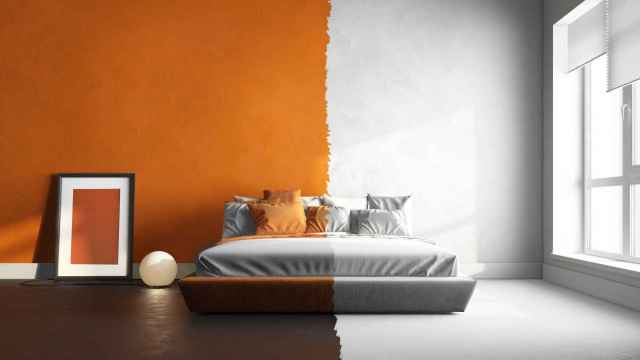 Dormitorio pintado la mitad en blanco y la mitad en naranja.