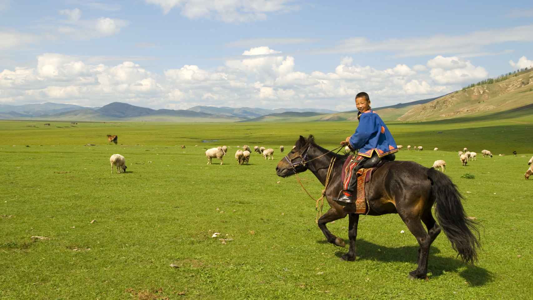 Un niño mongol montado en caballo.