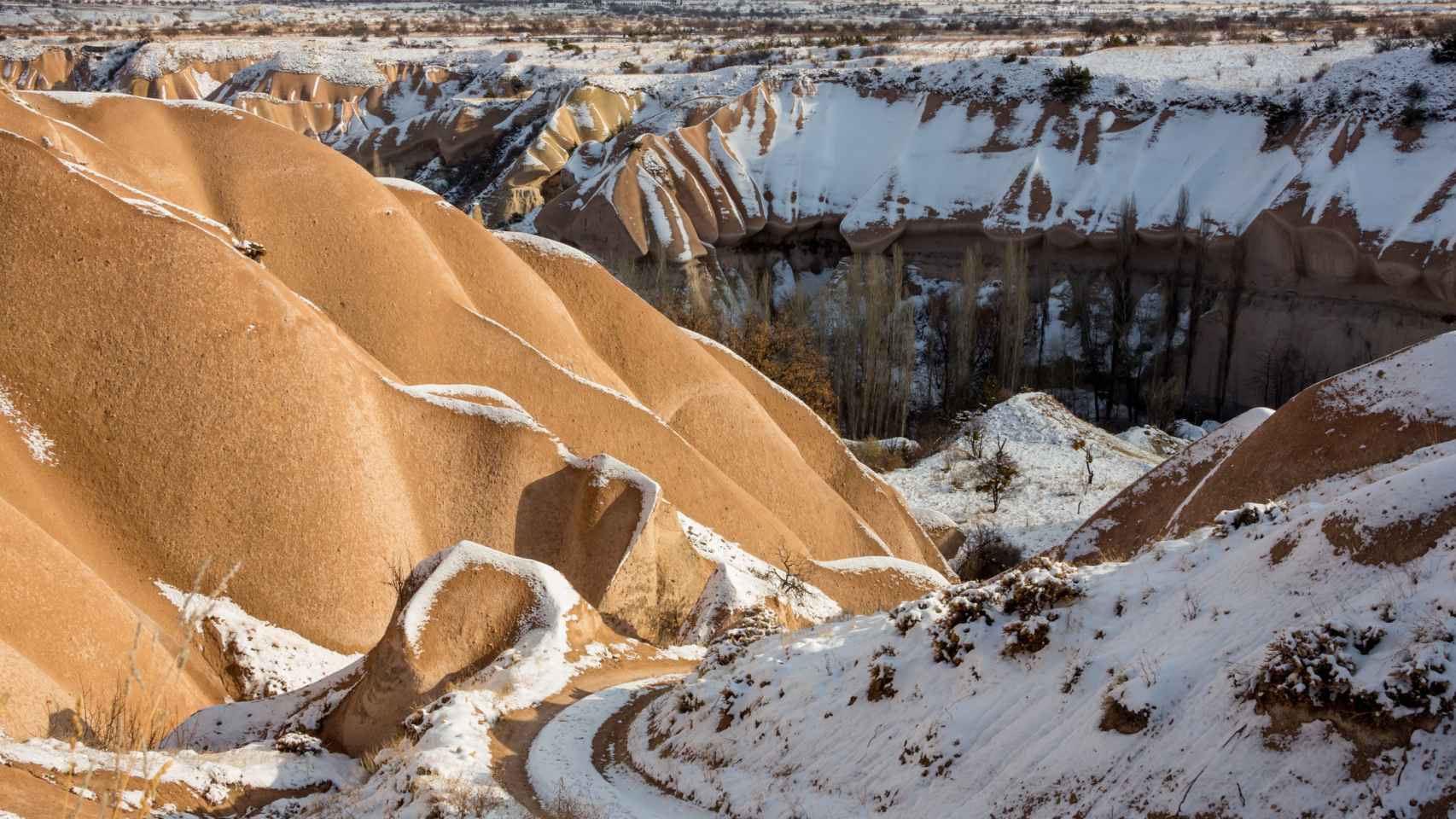 Picos cubiertos de nieve y dunas de arena en el desierto del Sahara en Merzouga (Marruecos).