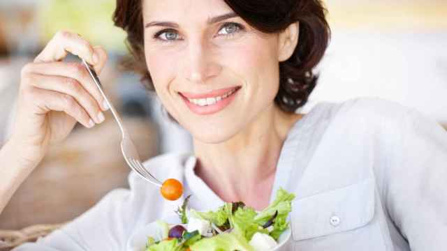 Una mujer comiendo que es la imagen de la salud y la vitalidad.