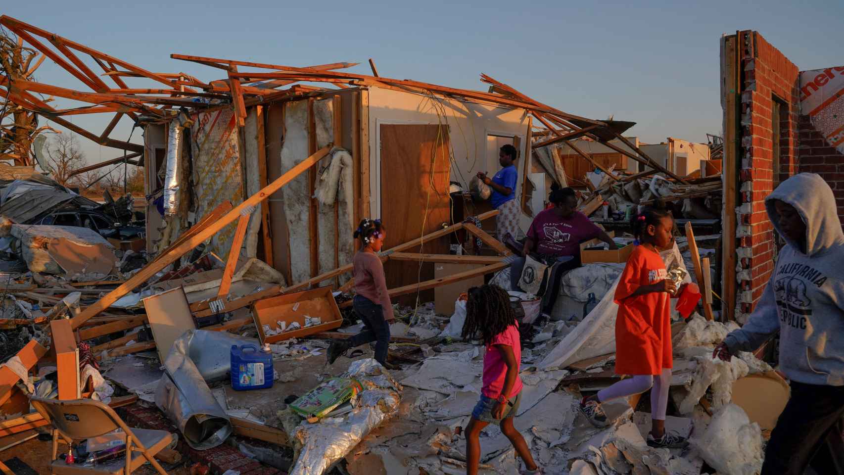 Familias intentan rescatar sus pertenencias entre los escombros de sus casas.