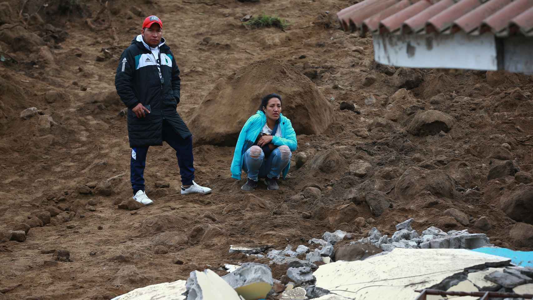 Sobrevivientes observan los daños causados por un deslizamiento de tierra en Alausí (Ecuador), este lunes