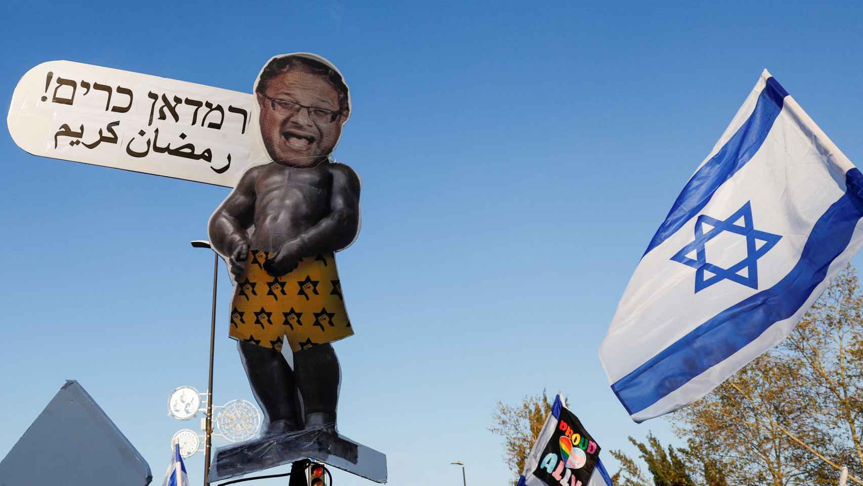 Un manifestante sostiene un cartel con el jefe del Ministro de Seguridad Nacional de Israel, Itamar Ben - Gvir , mientras asisten a una manifestación después de que el Primer Ministro de Israel, Ben Jamin Netanyahu, destituyera al Ministro de Defensa y su gobierno de coalición nacionalista presione con su reforma judicial.