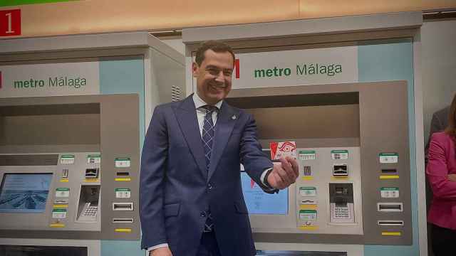 El presidente de la Junta de Andalucía, Juan Manuel Moreno Bonilla, muestra la tarjeta monedero del Metro de Málaga.