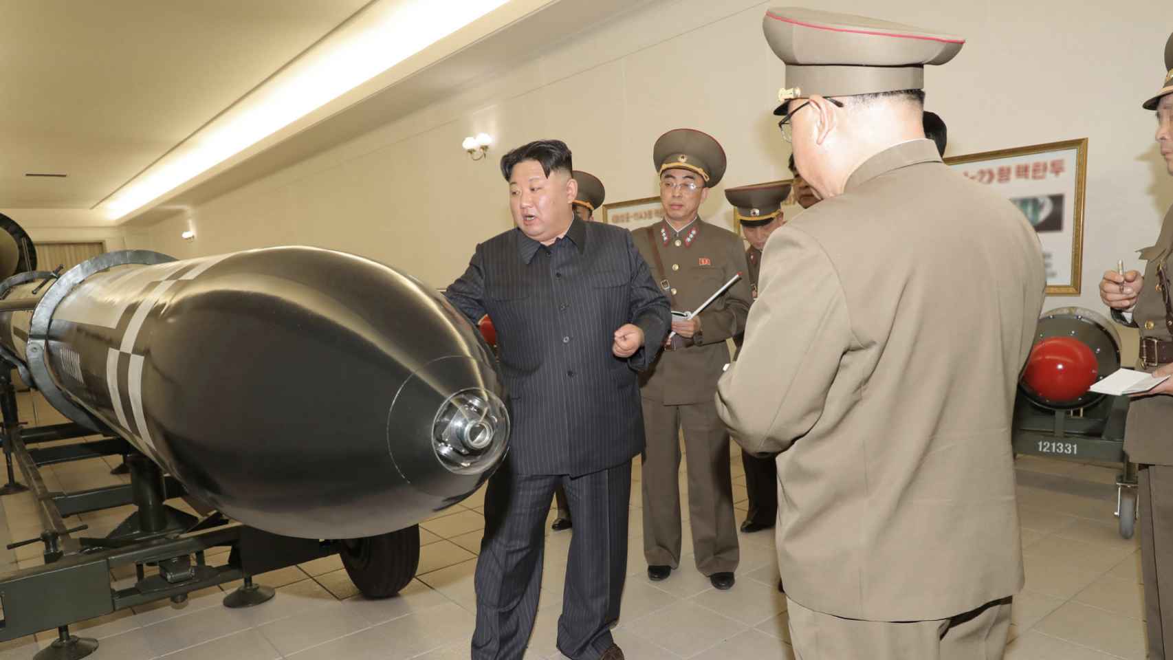 Kim junto a los militares del programa nuclear mirando un misil Hwasal-2