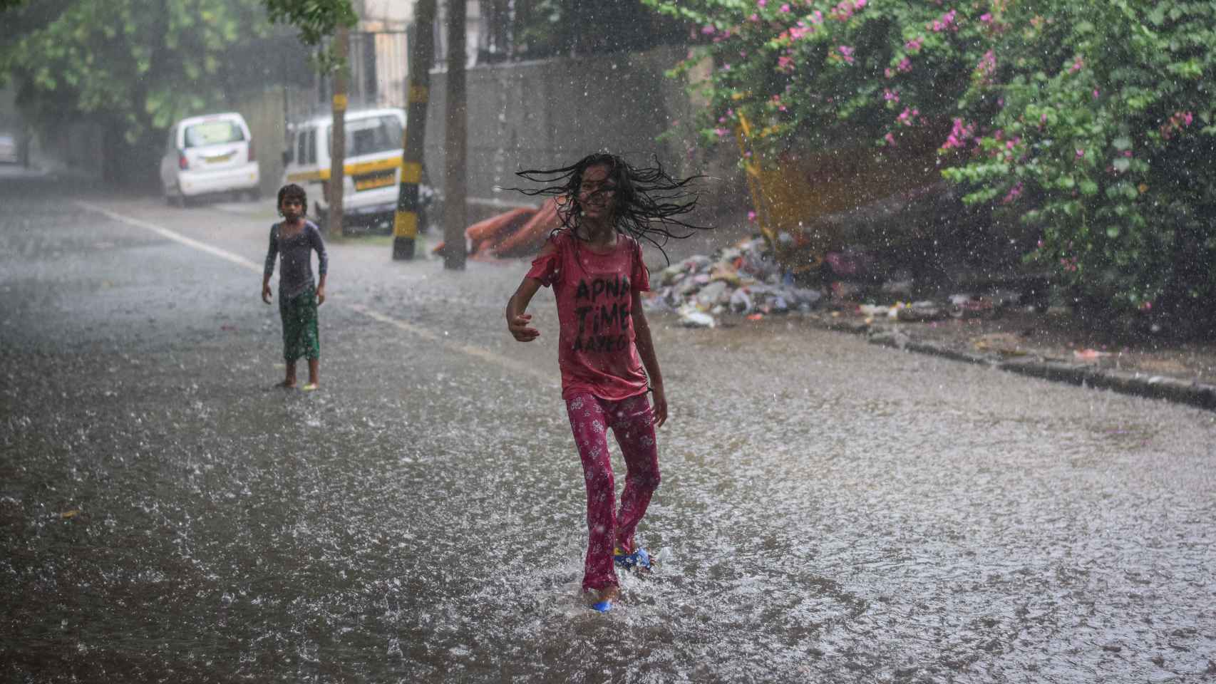 Una niña juega bajo la lluvia en Delhi, India.