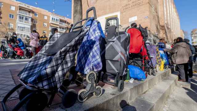 Varias personas hacen cola para recibir alimentos de la Fundación Madrina, en la plaza de San Amaro, a 7 de enero de 2022, en Madrid (España).