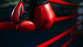 Guantes de boxeo colgando de las cuerdas de un ring