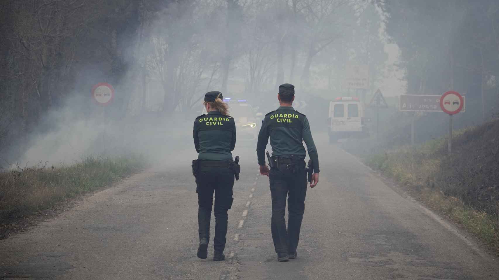 Dos agentes de la Guardia Civil regulan el tráfico en el incendio de los concejos de Valdes y Tineo.