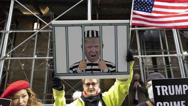 Una manifestante sostiene un cartel con una imagen de Trump tras las rejas en una protesta en Nueva York.
