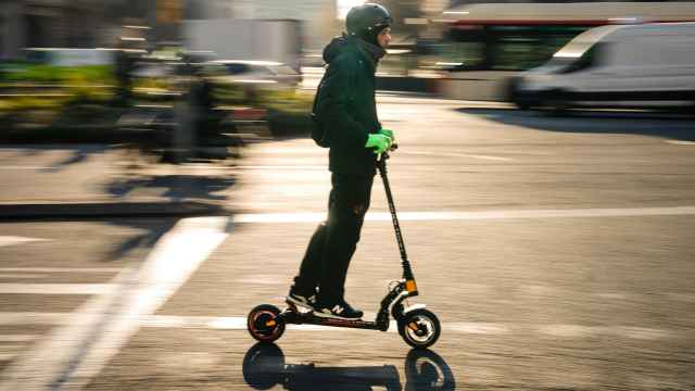 Un hombre circula por el centro de Barcelona con un patinete eléctrico.