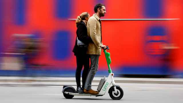 Dos personas circulan en un patinete eléctrico, en París.