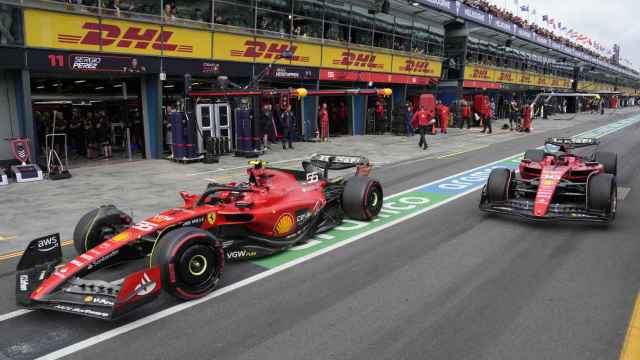 Charles Leclerc y Carlos Sainz, en el paddock de Ferrari con sus monoplazas.