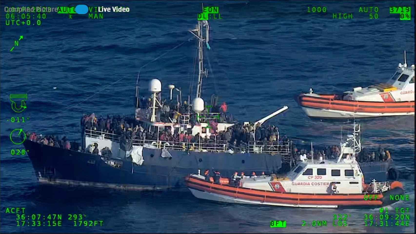 Migrantes esperan a ser rescatados por la Guardia Costiera frente a las costas de Italia.