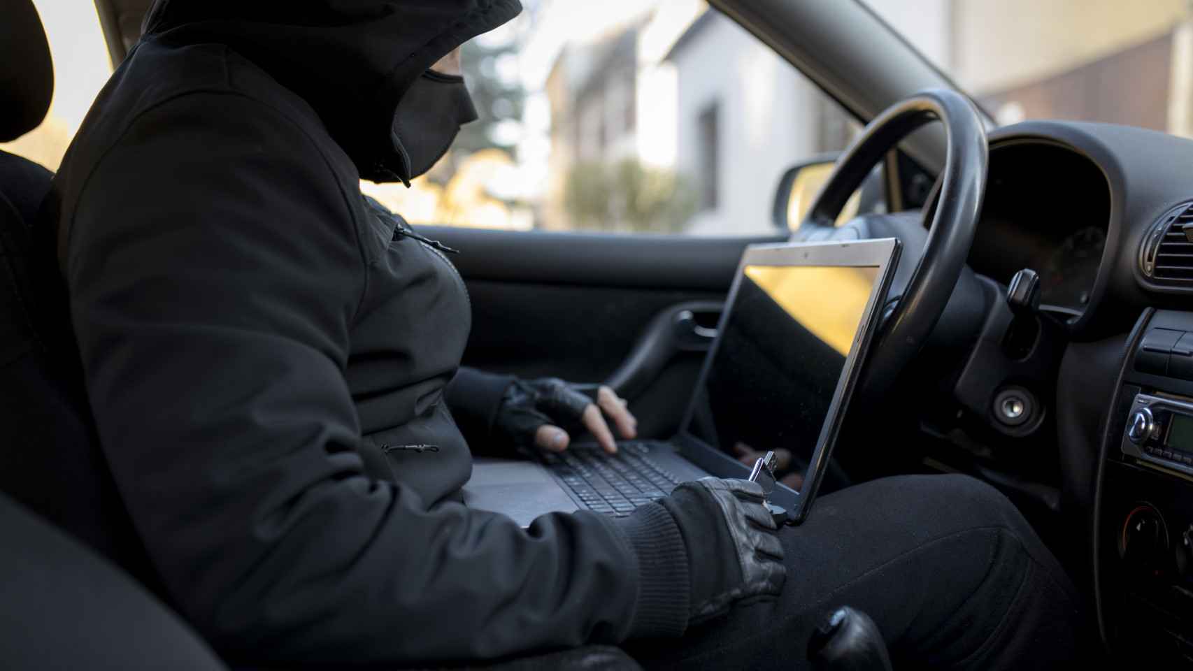 Un hacker con un ordenador dentro de un coche.
