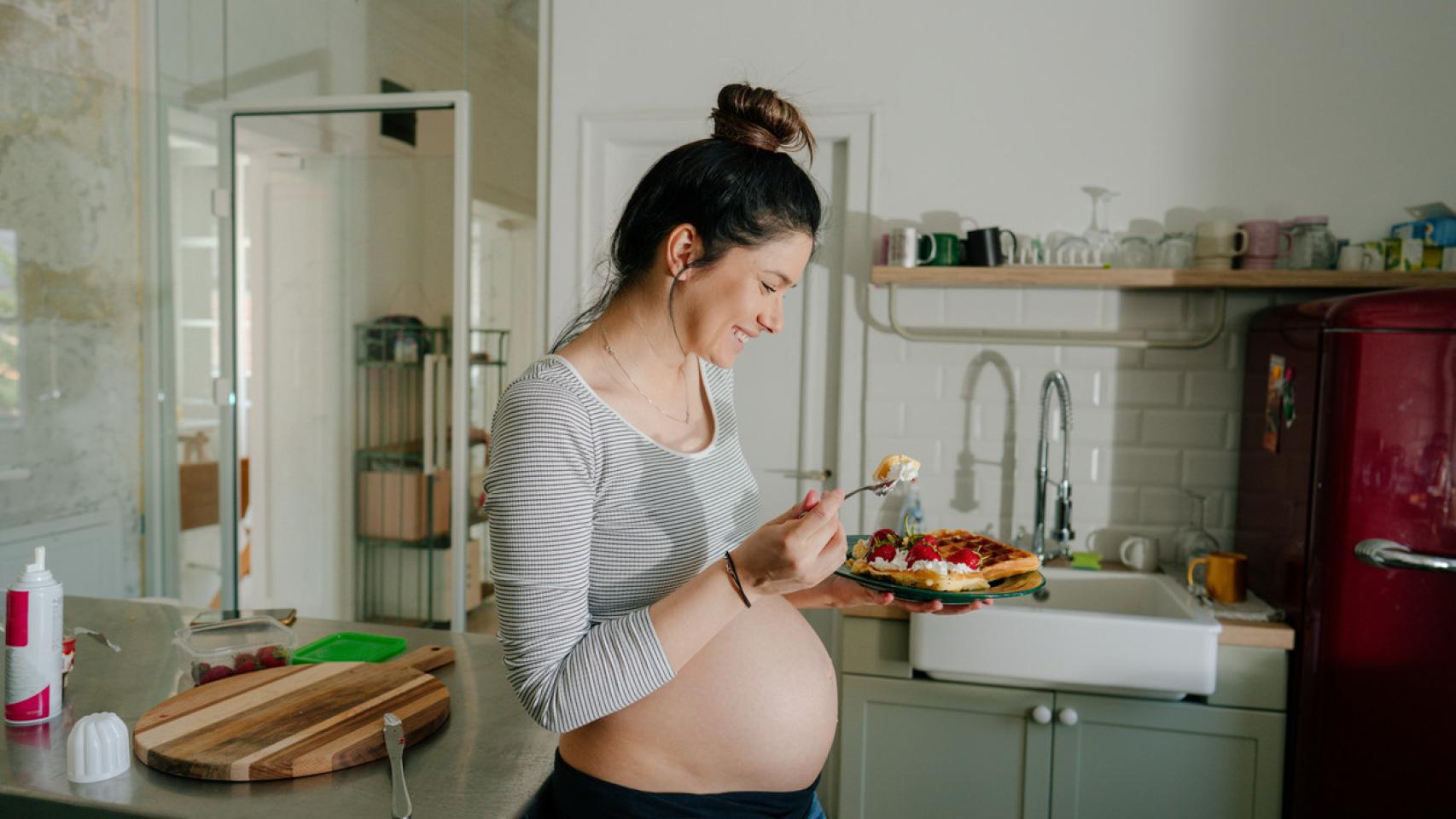 Mujer en su cocina comiendo.
