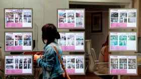 Una joven observa promociones en una inmobiliaria, en imagen de archivo.
