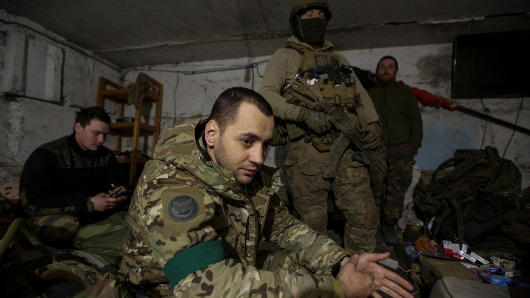 Ukrainian servicemen from the 24th Separate Mechanized Brigade rest inside a dugout in the frontline town of Bakhmut.