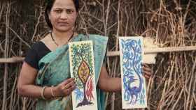 Gangubai Aamiliyar exhibiendo dos de sus creaciones artísticas.