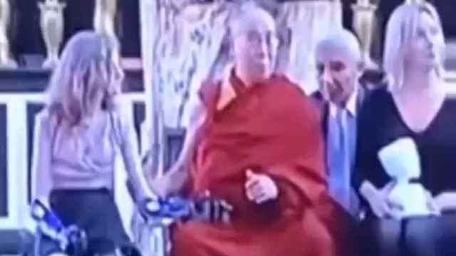 Dalái Lama acaricia de forma insistente a una niña con discapacidad.