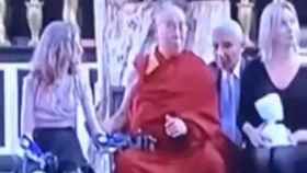 Dalái Lama acaricia de forma insistente a una niña con discapacidad.