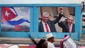 Raúl Castro (a la izquierda) sostiene el brazo del actual presidente cubano, Díaz-Canel, en un cartel electoral.