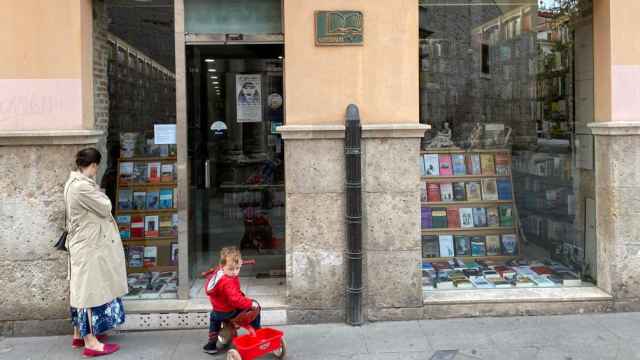 Una madre y su hijo miran el escaparate de una librería en Valladolid