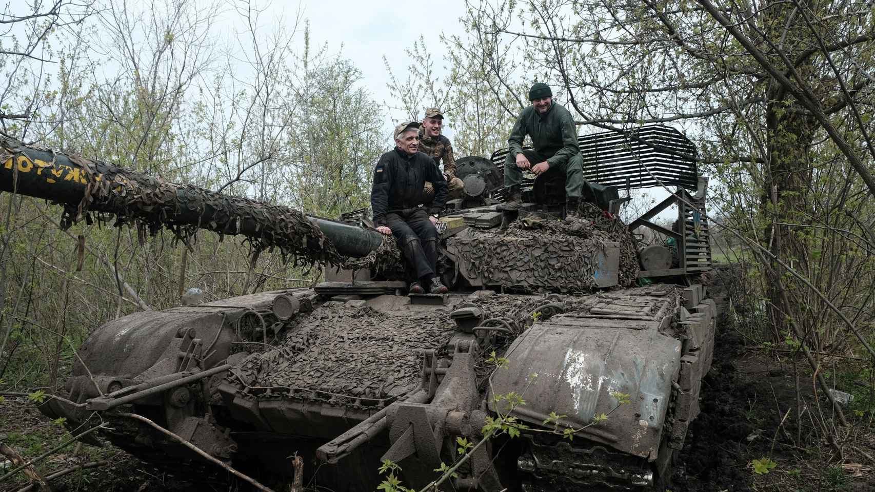 Gleb, Vitaly y Oleg, la tripulación del T-72 desplegado en el frente de combate de Bakhmut, posan para EL ESPAÑOL encima de su carro de combate.