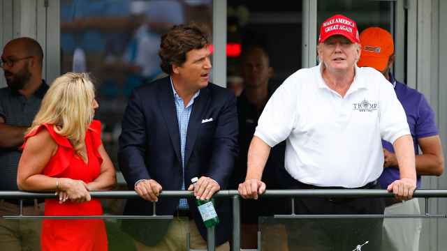 Tucker Carlson y Donald Trump junto a la congresista Marjorie Taylor Greene, en agosto de 2022.