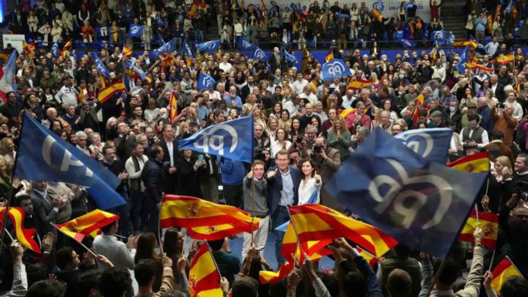 Almeid, Ayuso y Feijóo en un mitin en Madrid con banderas de España y del PP.