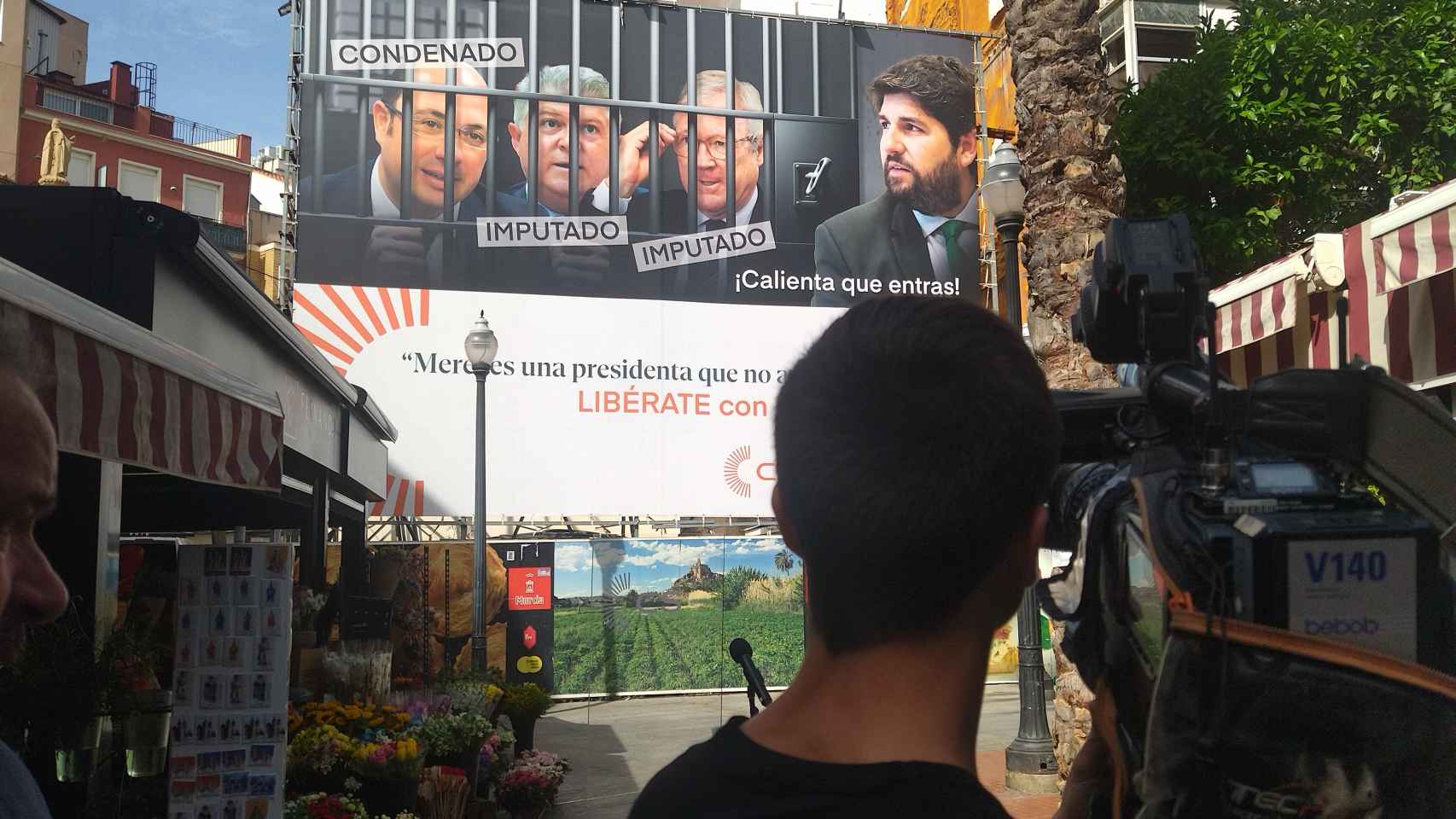 Un cámara de televisión, este viernes, grabando la lona gigante de Ciudadanos en la plaza de las Flores de Murcia.