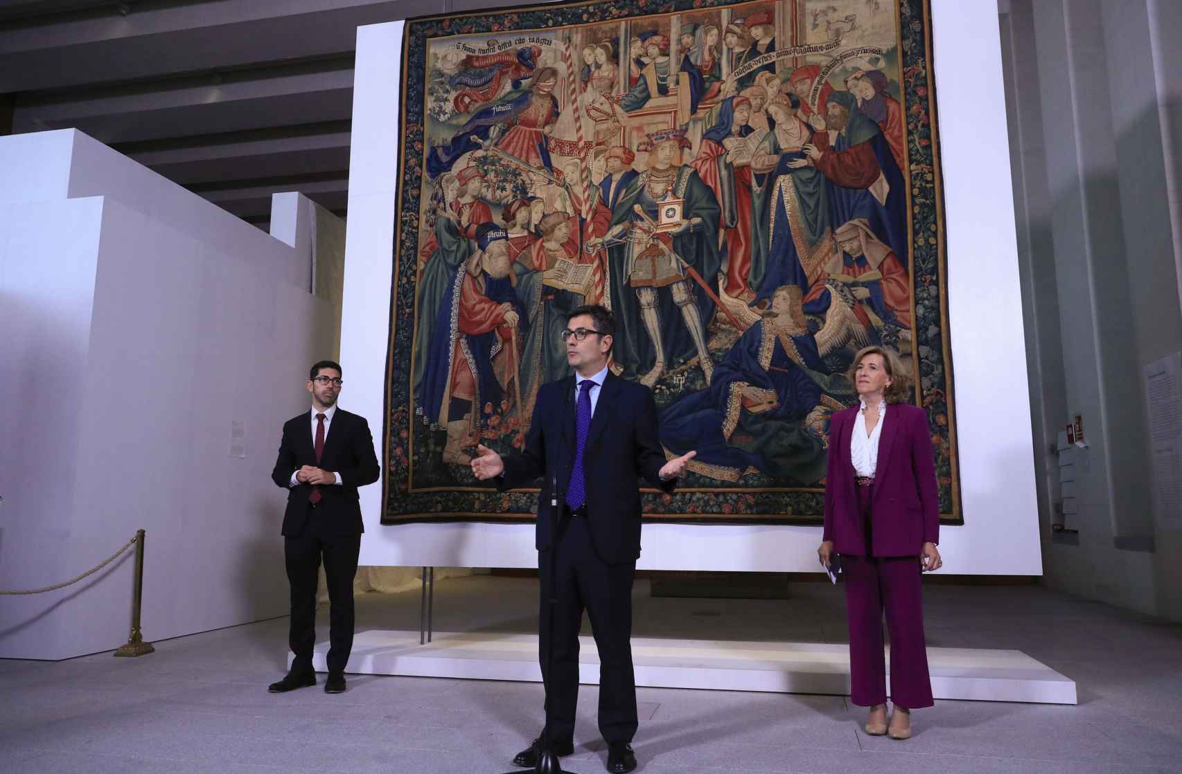 El ministro de la Presidencia, Félix Bolaños (c), junto con la presidenta de Patrimonio Nacional, Ana de la Cueva (d) presenta el tapiz 'El triunfo del tiempo'.