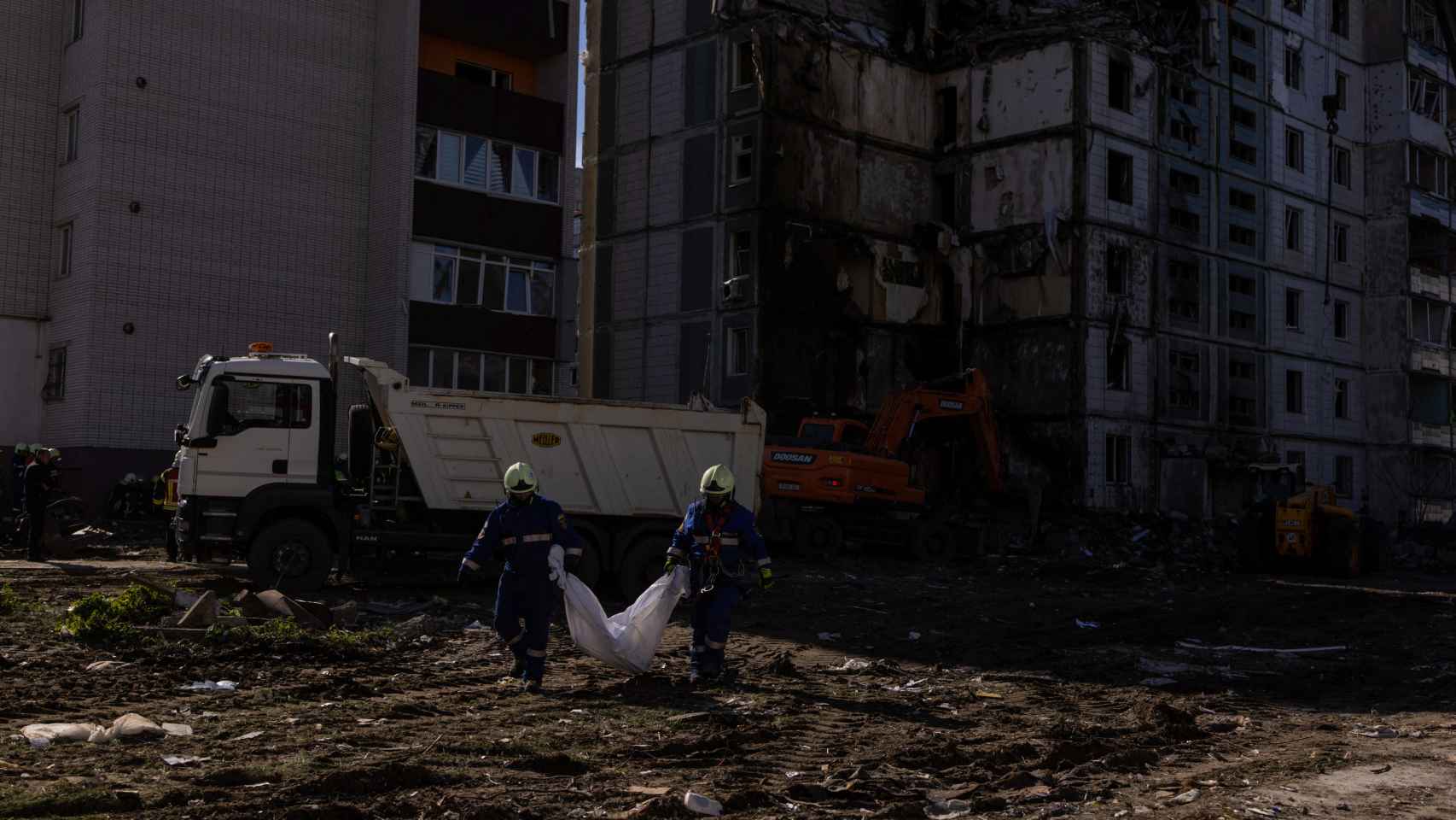 Two men carry a body after the Russian shelling in Uman this Friday.
