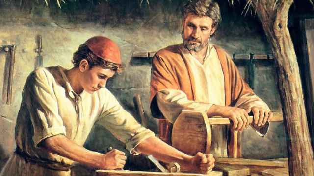 San José, trabajando como carpintero y enseñando a Jesús de niño.