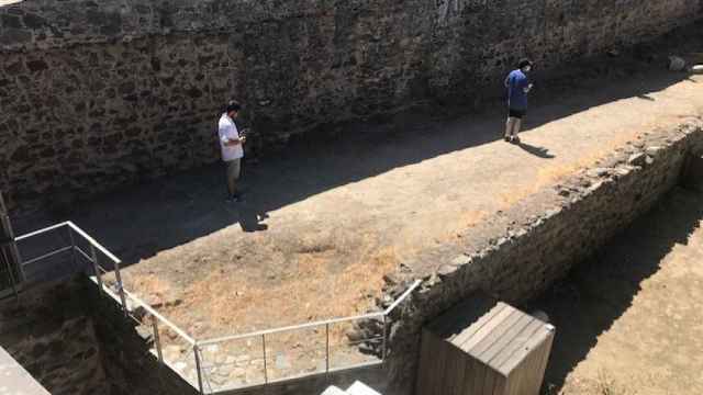 Varios turistas, testando la herramienta de la Universidad de Extremadura en unos restos arqueológicos.