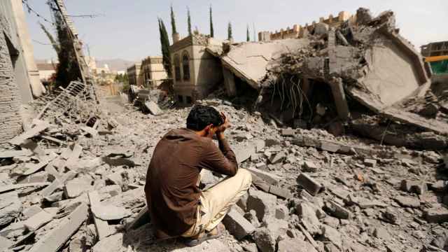 Un guardia sentado sobre los escombros de una casa, tras los ataques aéreos que la destruyeron Sanaa.