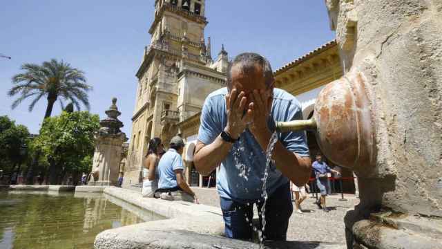 Un hombre se refresca en el Patio de los Naranjos de la Mezquita-Catedral de Córdoba, en abril de 2023.